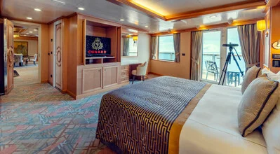 Queens Suite bedroom on Cunard with plush furnishings and ocean-view balcony